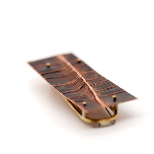 Fold-formed copper brooch with sculptural raised details